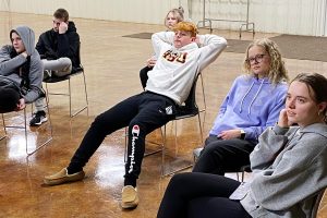 2 girls and 3 boys sit in chairs discussing a youth lesson at Faith Lutheran Church of McLean County.