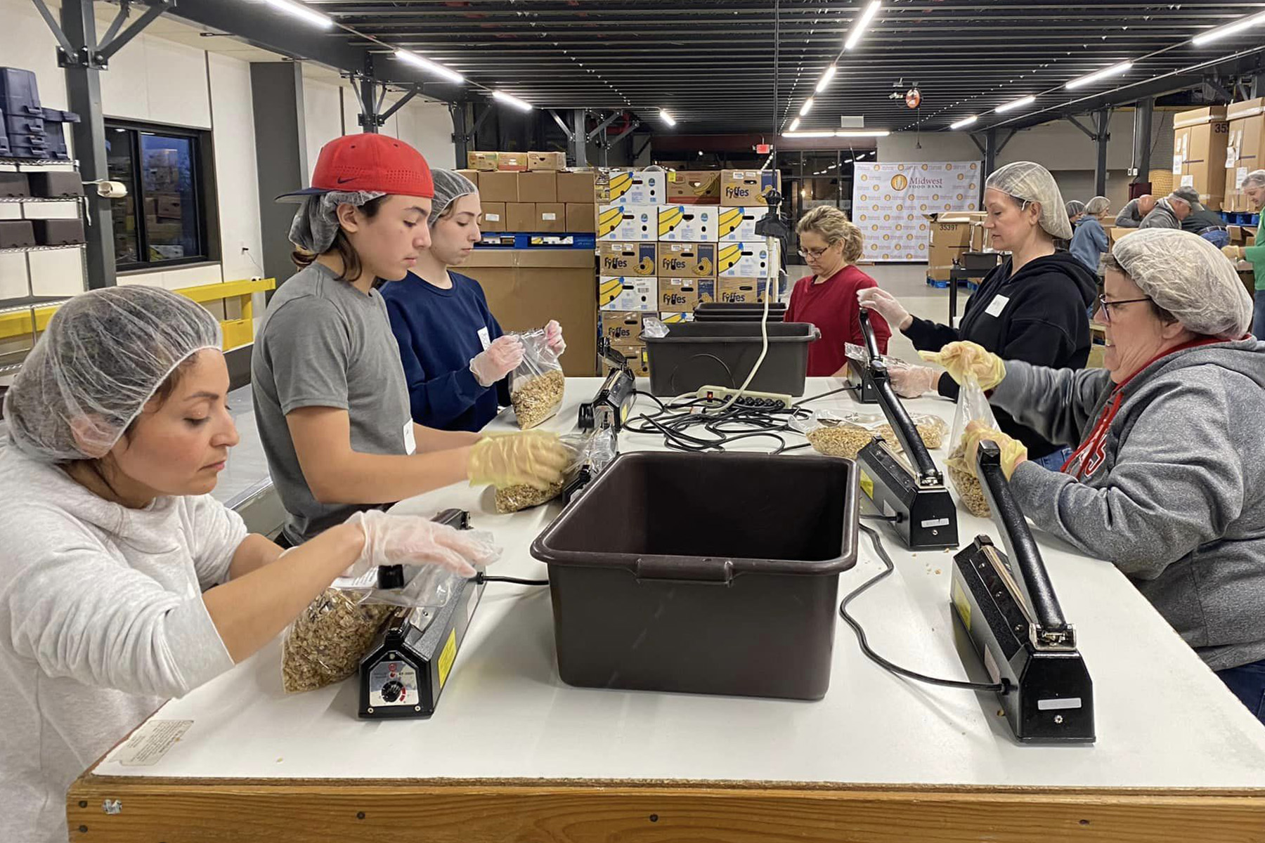 Several Faith Lutheran Church of McLean County youth and adults pack granola at Midwest Food Bank