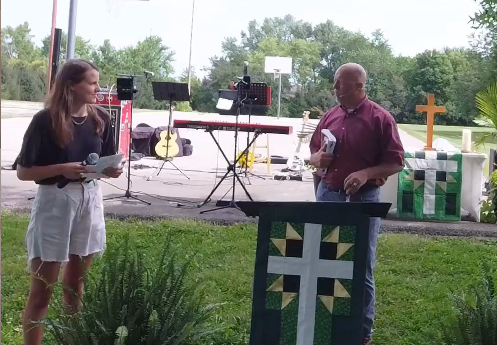 2 people speaking at a podium for outside worship at Faith Lutheran Church of McLean County in Bloomington Illinois