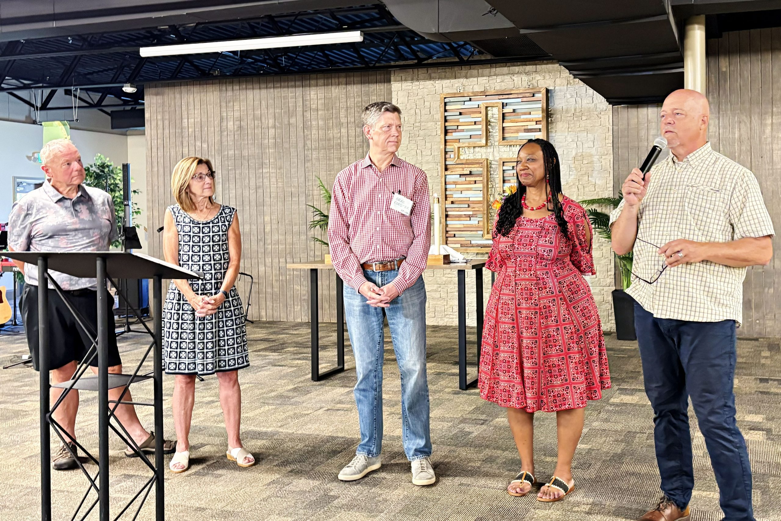 commission of 4 Partners during a Faith Lutheran Church of McLean County - Faith Church worship service. 4 people and the pastor in front of an altar and cross